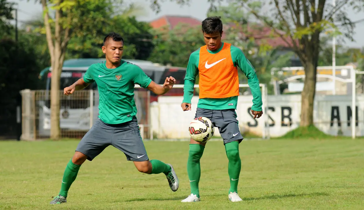 Gelandang timnas Indonesia U-23, Manahati Lestusen (kanan) berebut bola dengan rekan setimnya saat berlatih di Lapangan Sutasoma, Jakarta, (25/3/2015). Garuda Muda akan berlaga di kualifikasi Grup H Piala Asia 2016. (Liputan6.com/Helmi Fithriansyah)