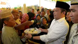 Menteri Desa, PDT dan Transmigrasi Marwan Jafar berbagi kue dengan warga saat melakukan kunjungan kerja ke Desa Huntu Barat, Bulango Selatan, Bone Bolango, Gorontalo, Minggu (10/1/2016). (Foto; Wahyu Wening/Humas Kemendes)