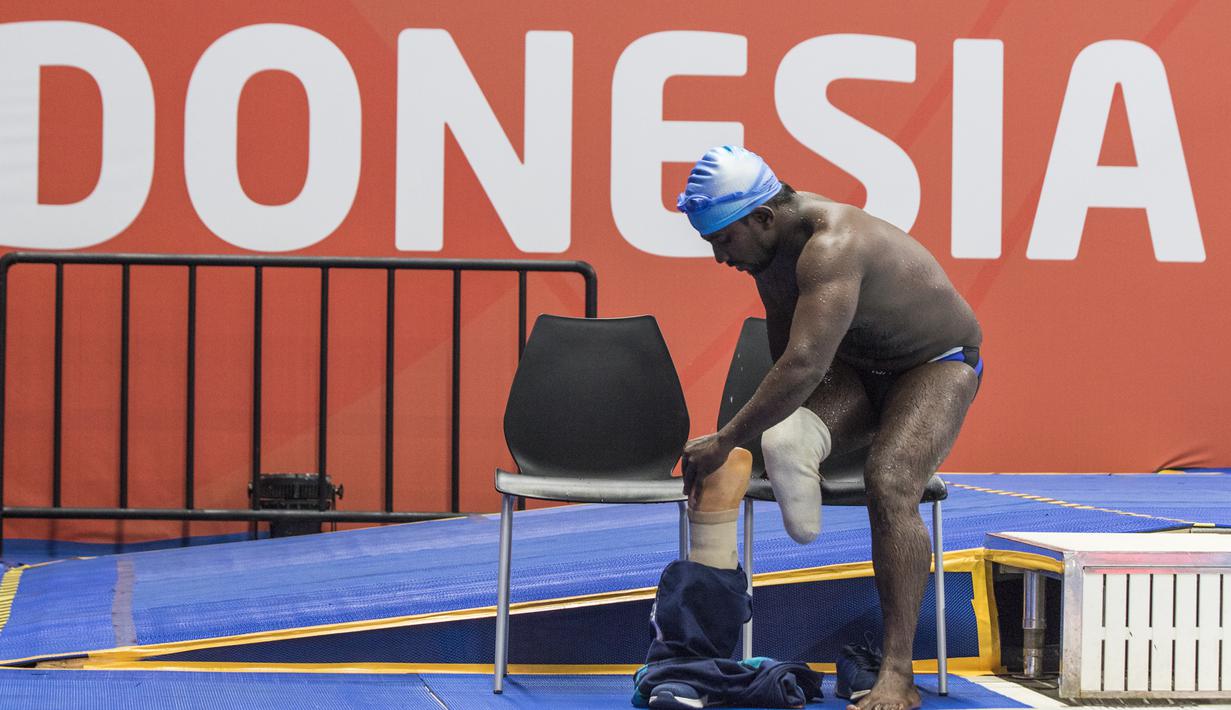 Perenang India, Mukundan Niranjan, memakai kaki palsu usai tampil pada nomor 50 meter gaya bebas di Stadion Aquatic, Stadion Aquatic Senayan, Jakarta, Minggu (7/10/2018). (Bola.com/Vitalis Yogi Trisna)