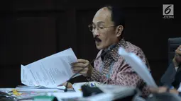 Terdakwa kasus merintangi penyidikan dugaan korupsi e-KTP, Fredrich Yunadi melihat-lihat berkas pada sidang lanjutan di Pengadilan Tipikor, Jakarta, Kamis (12/4). Sidang mendengar keterangan saksi. (Liputan6.com/Helmi Fithriansyah)
