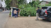 Pemilik warung menunjukan lokasi penemuan bungkusan mencurigakan di warungnya Jalan Raya Grogol, Kecamatan Limo, Kota Depok. Senin (5/4/2021). (Liputan6.com/Dicky Agung Prihanto)