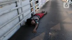 Seorang anak tertidur di Jembatan Penyebrangan Orang (JPO) kawasan Glodok, Jakarta Sabtu (22/7/2023). Berdasarkan data penyandang masalah kesejahteraan sosial anak jalanan yang dipublikasikan oleh Kementerian Sosial pada tahun 2012, jumlah anak jalanan di Indonesia mencapai angka 135.598 ribu jiwa. (merdeka.com/Imam Buhori)