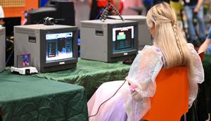 Seorang pengunjung memainkan permainan retro di pameran video game Gamescom di Cologne, Jerman bagian barat pada 23 Agustus 2023. (AFP/Ina Fassbeder)