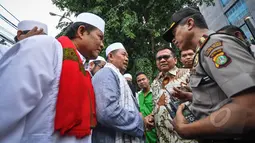 Petugas Kepolisian berbincang dengan perwakilan gerakan masyarakat Jakarta (GMJ) dan FPI di depan Gedung DPRD DKI Jakarta, Selasa (24/3/2015). Dalam aksinya, mereka meneriakkan dukungan terhadap hak angket DPRD DKI Jakarta. (Liputan6.com/Faizal Fanani)