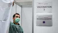 Seorang tentara Swiss menutup tirai bilik sebelum memberikan suntikan vaksin booster COVID-19 Moderna di Delemont, Swiss, 14 Desember 2021. Swiss yang dilanda gelombang infeksi baru COVID-19 telah memanggil tentara untuk mempercepat vaksinasi.
(Fabrice COFFRINI/AFP)