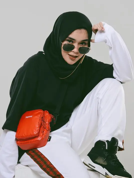 Sporty dan elegan sepertinya cocok untuk gaya Sivia yang satu ini. Nuansa monokrom sangat mempertegas gayanya yang sporty ini. Hanya saja, ia memadukan dengan tas kecil yang berwarna merah. (Instagram/siviazizah)