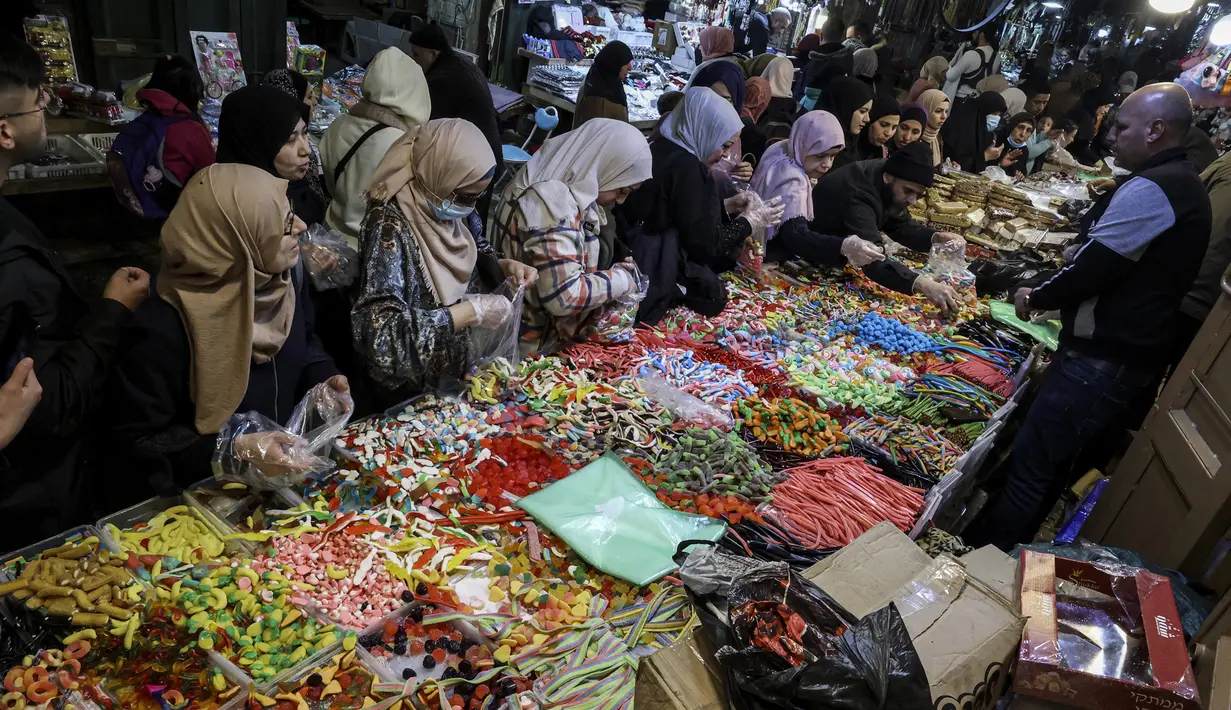 Warga Palestina berbelanja manisan menyambut datangnya bulan suci Ramadhan di Kota Tua Yerusalem, 28 Maret 2022. (HAZEM BADER/AFP)