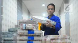 Karyawan memeriksa pasokan uang di Cash Pooling Bank Mandiri, Jakarta, Kamis (9/5/2019). Bank Mandiri menyiapkan dana tunai sebesar Rp1,9 triliun per hari selama Ramadan hingga jelang Idul Fitri 2019. (Liputan6.com/Angga Yuniar)