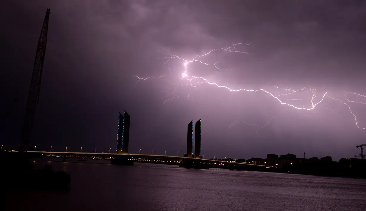 Kilatan petir yang terlihat diatas jembatan Bordeaux, Prancis (18/7). Kilatan ini hiasi langit Prancis saat terjadi badai petir. (AFP Photo/Nicolas Tucat)