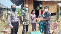 Personil Polres Mamuju Utara saat menyelurkan bantuan sembako kepda warga di Dusun Saluraya, Pasangkayu (Liputan6.com/Abdul Rajab Umar)