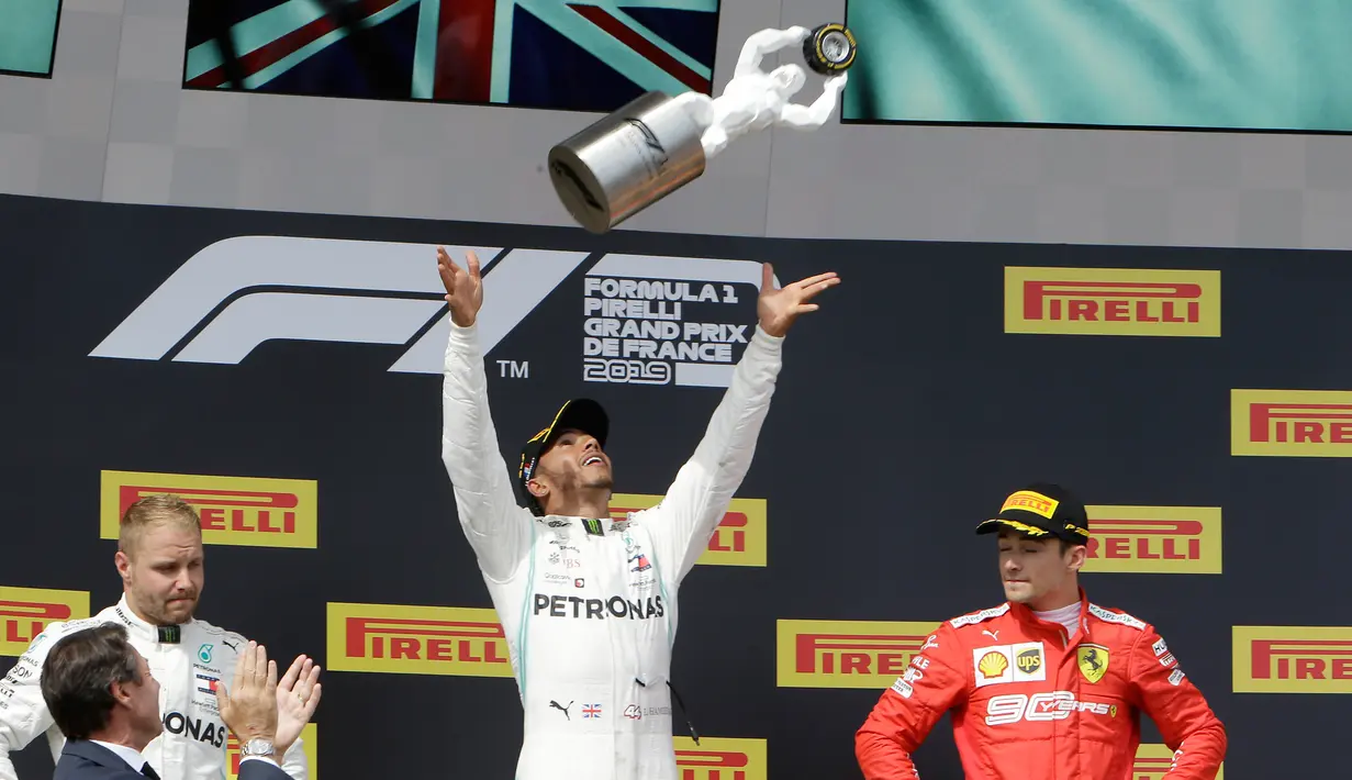 Pebalap Mercedes Lewis Hamilton (tengah) melemparkan trofi juara ke udara didampingi pebalap Mercedes Valtteri Bottas (kiri) dan pebalap Ferrari Charles Leclerc setelah menjuarai F1 GP Prancis 2019 di Sirkuit Paul Ricard, Minggu (23/6/2019). (AP Photo/Claude Paris)