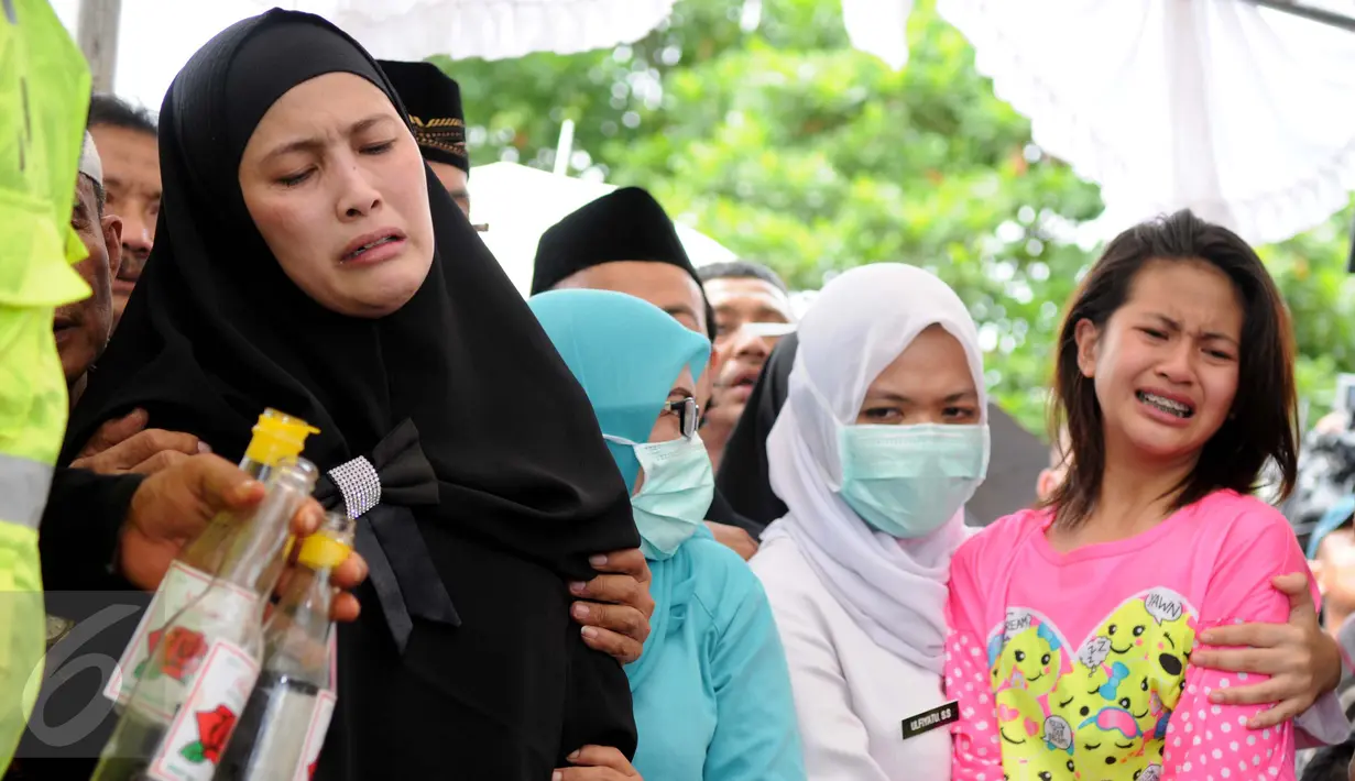 Istri kedua Dodi Triono, Almianda Saphira dan sang putri Zanette Kalila Azaira (13) menangis histeris saat prosesi pemakaman jenazah korban pembunuhan Pulomas di TPU Tanah Kusir, Jakarta, Rabu (28/12). (Liputan6.com/Gempur M Surya)