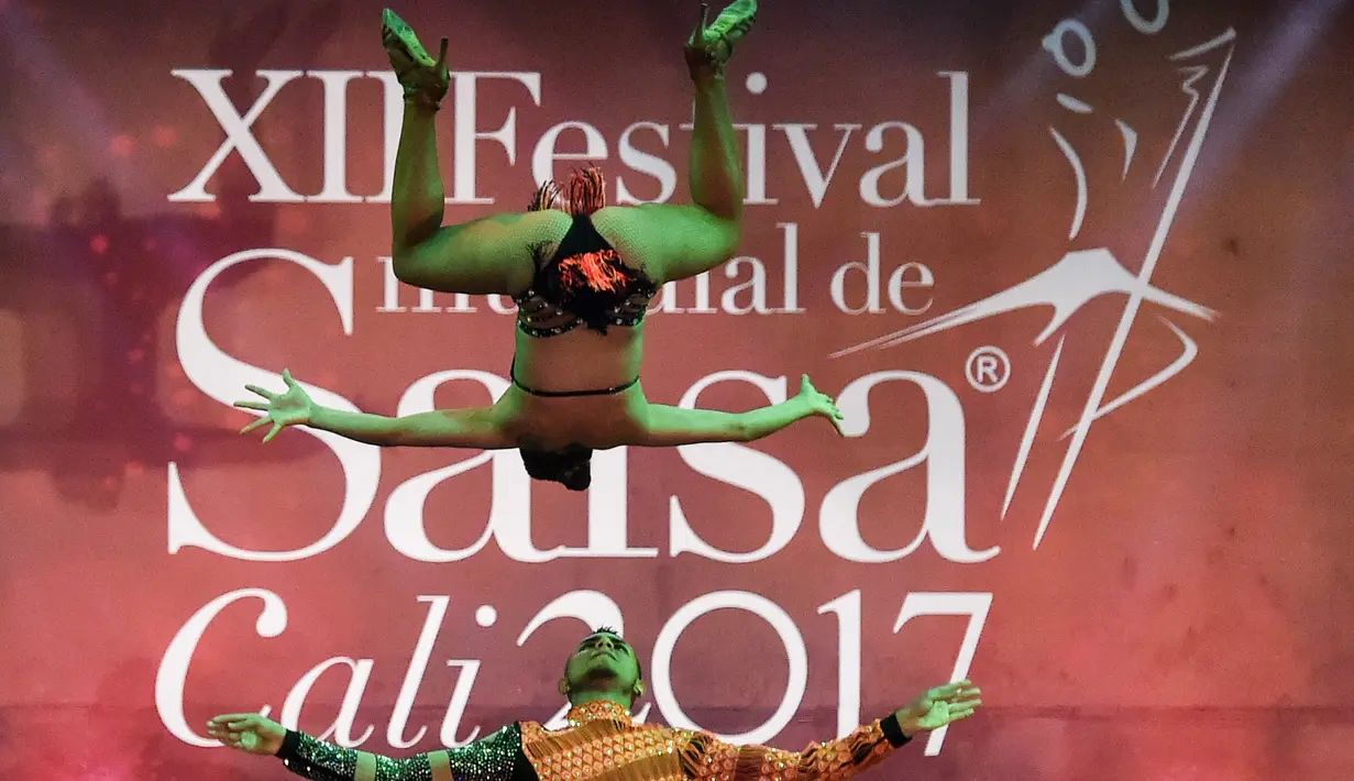 Penari salsa asal Kolombia Angie Adrada (atas) melakukan aksi akrobatik saat tampil dalam kategori Pasangan Cabaret di Festival Salsa Dunia XII, di Cali, Kolombia (1/10). (AFP Photo/Luis Robayo)