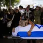 Dan kesedihan terus merebak di seluruh Israel, ketika para ibu menguburkan anak-anak mereka, bendera dan bunga berjejer di lebih banyak kuburan. (AP Photo/Francisco Seco)