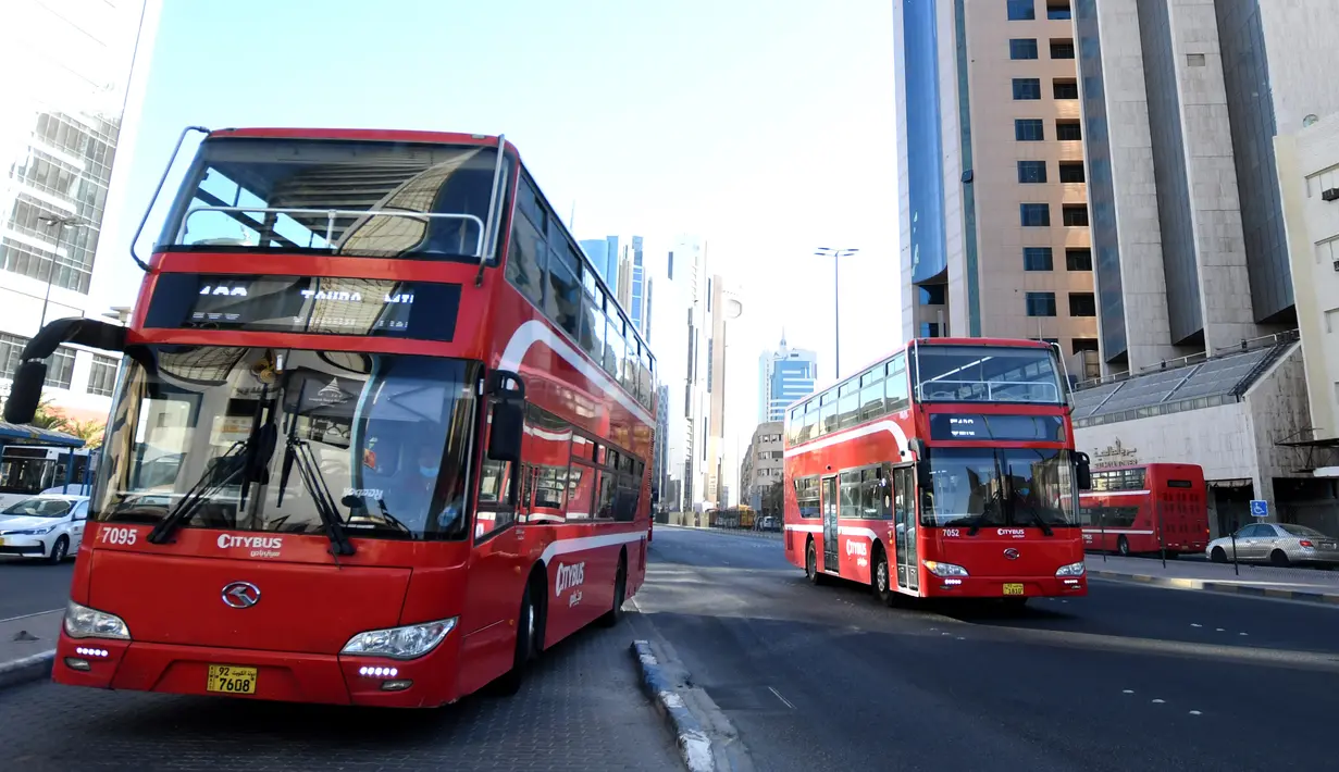 Sejumlah bus melaju di sebuah jalan di Kuwait City, Kuwait (18/8/2020). Pemerintah negara itu mengizinkan salon, pusat kebugaran, tempat pangkas rambut, penjahit, dan spa untuk kembali beroperasi, sementara restoran dapat menawarkan lebih banyak layanan. (Xinhua/Ghazy Qaffaf)