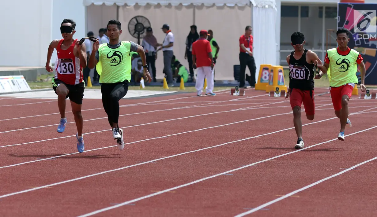 Pelari difable Indonesia, Dalimunte Abdul Hakim (kiri) saat berlaga melawan Setiawan Nanang di kelas Mens 100m T45/46/47 Indonesia Para Games Invitational Tournament 2018 di Stadion Madya Senayan, Jakarta, Minggu (1/7). (Liputan6.com/Helmi Fithriansyah)