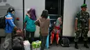 Warga ex Gafatar sedang menunggu untuk menaiki bus di Dermaga Kolinlamil Tanjung Priok, Jakarta, Rabu (27/01) Warga eks Gafatar nantinya akan dibawa ke Rumah Aman Buperta Cibubur, Jakarta Timur. (Liputan6.com/Faizal Fanani)
