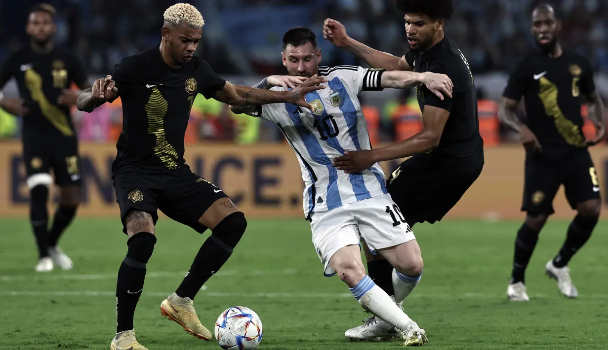 Pemain Timnas Argentina, Lionel Messi berusaha melewati sejumlah pemain Curacao pada laga uji coba internasional yang berlangsung di Stadion Unico Madre de Ciudades, Rabu (29/3/2023) pagi WIB. La Pulga berhasil mencetak hattrick dan membawa timnya menang dengan skor 7-0. (AFP/Juan Mabromata)