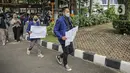 Sejumlah mahasiswa UNY berjalan dengan membawa kertas bertuliskan tuntutan saat akan menggelar aksi di depan Gedung Kemendikbud, Jakarta, Jumat (10/2/2023). Dengan memaksa masuk untuk melakukan aksi di dalam lingkungan Kemendikbud, mahasiswa UNY memberikan baju dansa sebagai bentuk protes terkait mahalnya biaya kuliah di Indonesia. (Liputan6.com/Faizal Fanani)