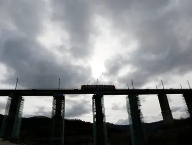 Lokomotif melintas di jembatan kereta yang dalam proses penyelesaian di Taiga, dekat stasiun Dzheb, Krasnoyarsk, 10 Oktober 2016. Rusia membangun jembatan kereta tertinggi di negaranya yang merupakan proyek Trans-Siberian Railway (REUTERS/Ilya Naymushin)