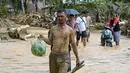 Sementara, data terbaru Badan Nasional Penanggulangan Bencana (BNPB) pada 2 Desember 2025, menyebut, secara keseluruhan, korban tewas akibat rangkaian banjir dan tanah longsor yang melanda sejumlah wilayah di Pulau Sumatera sejak pekan lalu telah mencapai 712 jiwa. Tampak dalam foto, warga berjalan di tengah banjir bandang di Desa Tukka, Tapanuli Tengah, Sumatera Utara, pada 2 Desember 2025. (YT HARIONO/AFP)