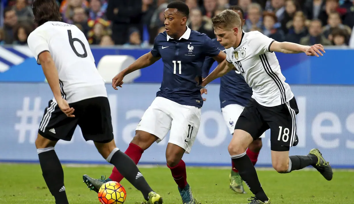 Penyerang Perancis, Anthony Martial (tengah) berusaha melewati bek Jerman, Matthias Ginter pada laga persahabatan di stadion Stade de France, Perancis, (13/11). Perancis menang atas Jerman dengan skor 2-0. (REUTERS/Benoit Tessier)