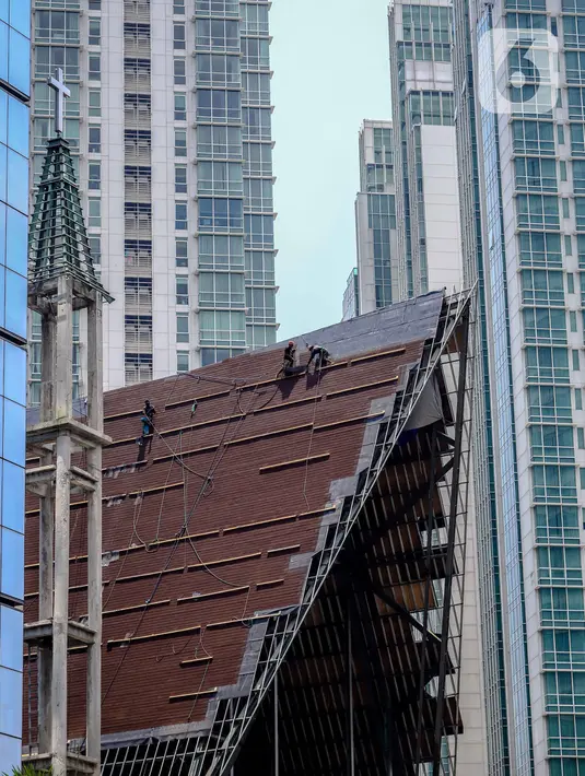 Aktivitas pekerja di atas atap gereja tanpa alat pengaman lengkap, Jakarta, Rabu (12/2/2020). Kemnaker mengatakan tingginya angka kecelakaan kerja di Indonesia disebabkan tidak maksimalnya penerapan K3 yang diatur dalam UU No1 Tahun 1970 tentang Keselamatan Kerja. (Liputan6.com/Faizal Fanani)