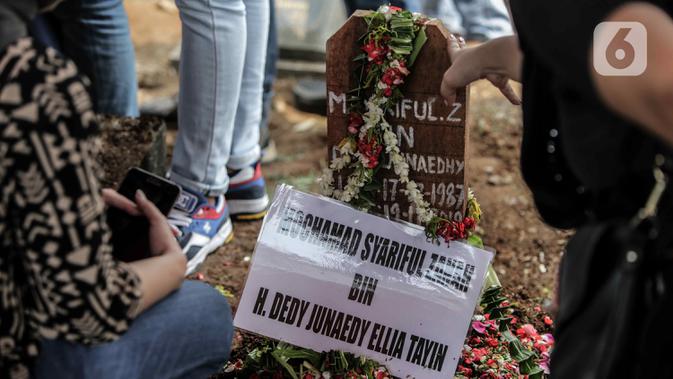 Bunga ditempatkan pada nisan mantan artis cilik Cecep Reza saat pemakaman di TPU Layur Penggilingan, Jakarta, Rabu (20/11/2019). Cecep Reza meninggal pada usia 31 tahun karena penyakit jantung. (Liputan6.com/Faizal Fanani)