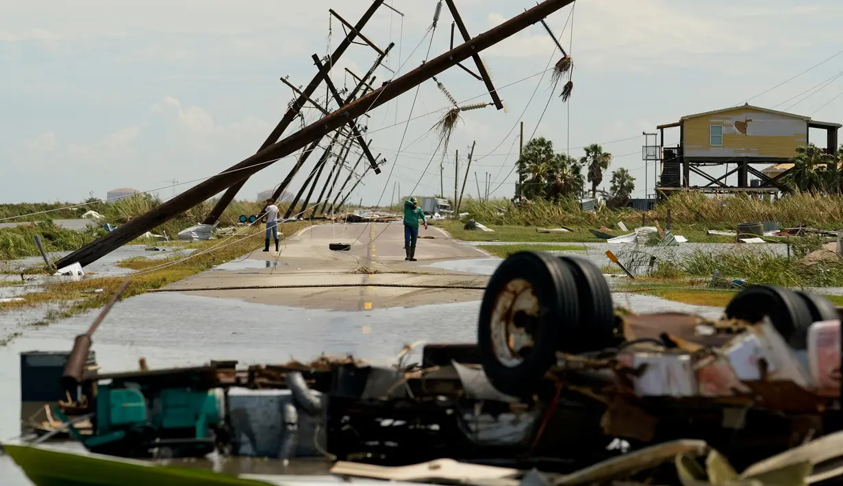 Orang-orang mengamati kerusakan yang ditinggalkan setelah Badai Laura mendarat di Holly Beach, Louisiana, AS, Kamis (27/8/2020). Laura merupakan badai tingkat empat yang masuk kategori monster. (AP Photo/Eric Gay)
