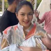 Dengan wajah natural tanpa riasan berlebih, Jessica Mila pun menggendong dengan erat putrinya yang diselimuti kain warna biru bergambar. [@putrihasibuan]