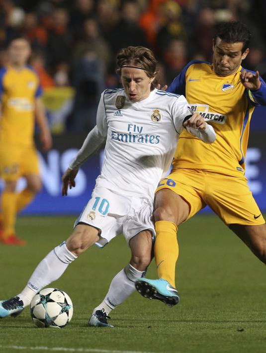 Pemain Real Madrid, Luka Modric (kiri) melewati adangan pemain APOEL, Nuno Morais pada laga Liga Champions grup H di GSP stadium, Nicosia, (21/11/2017). Madrid menang 6-0. (AP/Petros Karadjias)