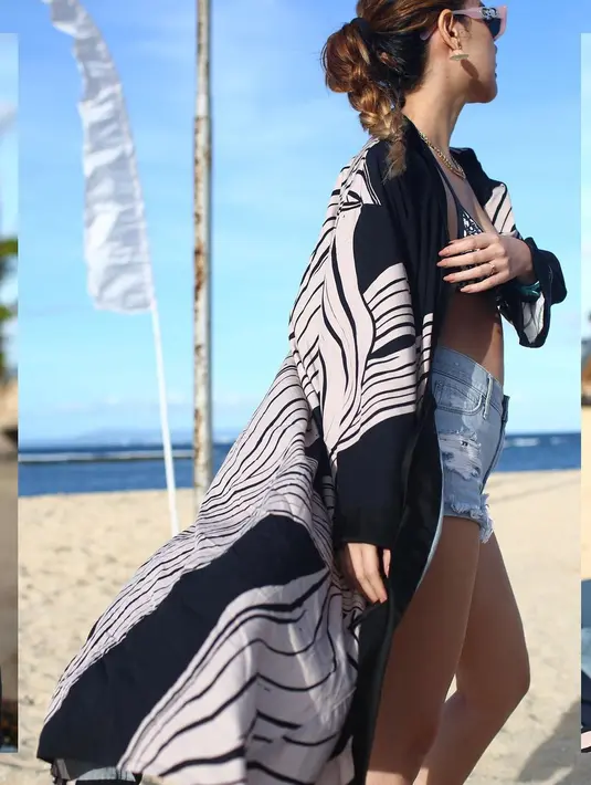 Pelantun lagu Kecewa ini memamerkan potret seksinya berpose di pinggir pantai. BCL Tampil seksi memakai bikini hitam dengan hot pants yang dibalut outer panjang, tak ketinggalan, aksesori anting, kalung emas, dan kacamata pink pun turut disematkan sebagai pelengkap. (Instagram/@bclsinclair)