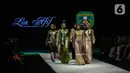 Model mengenakan busana kain rancangan karya LIA AFIF fashion desainer berkolaborasi dengan Pemkab Kutai Timur pada Indonesia Fashion Week 2022 di Jakarta Convention Center, Rabu (13/4/2022). Perhelatan Indonesia Fashion Week mengangkat tema "Magnificient Borneo". (Liputan6.com/JohanTallo)