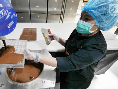 Pekerja memasukkan cokelat cair ke dalam alat cetak di toko Pipiltin Cocoa kawasan Barito, Jakarta, Kamis (13/9). Pipiltin Cocoa cukup banyak diburu oleh para atlet Asian Games 2018. (Liputan6.com/Herman Zakharia)