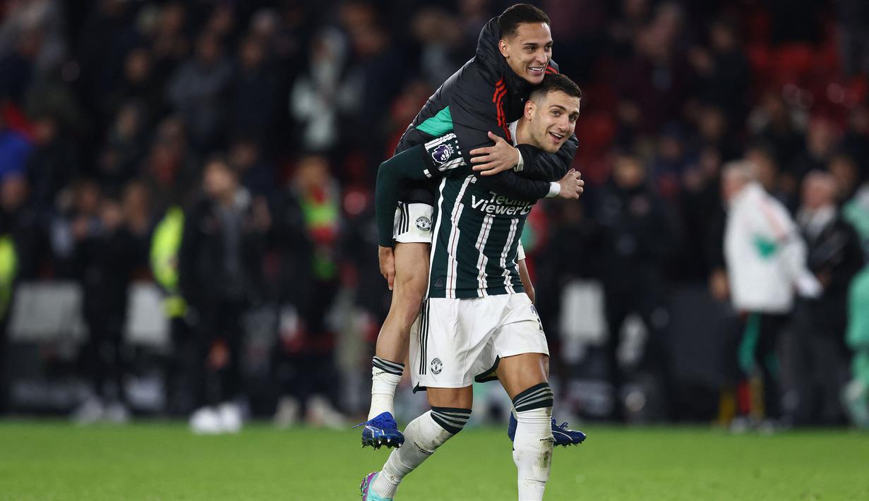 Bek Manchester United, Digo Dalot bersama rekannya, Antony merayakan kemenangan 2-1 timnya atas Sheffield United setelah berakhirnya laga pekan ke-9 Liga Inggris 2023/2024 di Bramall Lane, Sheffield, Minggu (22/10/2023) dini hari WIB. (AFP/Darren Staples)