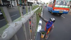 Pekerja mengecat pagar pembatas jalan di kawasan Pasar Minggu, Jakarta Selatan, Rabu (26/10). Pengecatan dilakukan sebagai bentuk perawatan agar pagar pembatas tetap rapi dan tidak tampak kusam. (Liputan6.com/Immanuel Antonius)