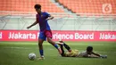 Pemain Barcelona U-18 Jorge Javier Espinal Díaz (kiri) menggiring bola melewati kiper Bali United U-18 I Komang Aryantara pada pertandingan International Youth Championship (IYC) 2021 di Jakarta International Stadium (JIS), Jakarta, Minggu (17/4/2022). (Liputan6.com/Faizal Fanani)