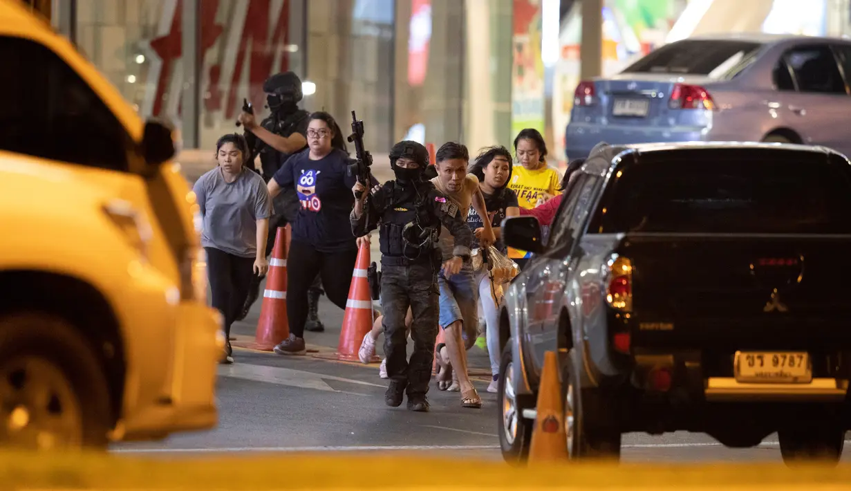 Tentara Thailand Tembaki Pengunjung Mal: Tentara mengawal pengunjung yang keluar dari mal Terminal 21 Korat saat terjadi penembakan di Nakhon Ratchasima, Thailand, Minggu (9/2/2020). Seorang tentara tanpa alasan jelas memberondong tembakan di mal itu. (AP Photo/Sakchai Lalitkanjanakul)