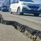 Kendaraan roda empat melintas pada jalan retak di Kabupaten Pidie Jaya, Aceh, Kamis (8/12). Gempa berkekuatan 6,5 SR pada Rabu pagi menyebabkan sejumlah ruas jalan retak dan mengalami kerusakan. (Liputan6.com/Angga Yuniar)