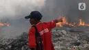 Seorang pria menunjuk ke arah api yang membakar rumah semi permanen dan lapak barang bekas di Bintara Jaya, Bekasi, Jawa Barat, Kamis (21/9/2023). (merdeka.com/Imam Buhori)