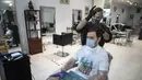 Tukang cukur menata rambut kliennya pada hari pertama berakhirnya lockdown di salon kecantikan Persona, Moskow, Rusia, Selasa (9/6/2020). Warga Moskow bebas beraktivitas setelah dua bulan menjalani lockdown akibat pandemi virus corona COVID-19. (AP Photo/Pavel Golovkin)