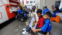 Aktivitas siswa penyandang disabilitas membaca buku pada perpustakaan keliling Sudin perpustakaan Jakarta Selatan di halaman Sekolah YPAC, jakarta, Jumat (29/11/2024). (merdeka.com/Arie Basuki)