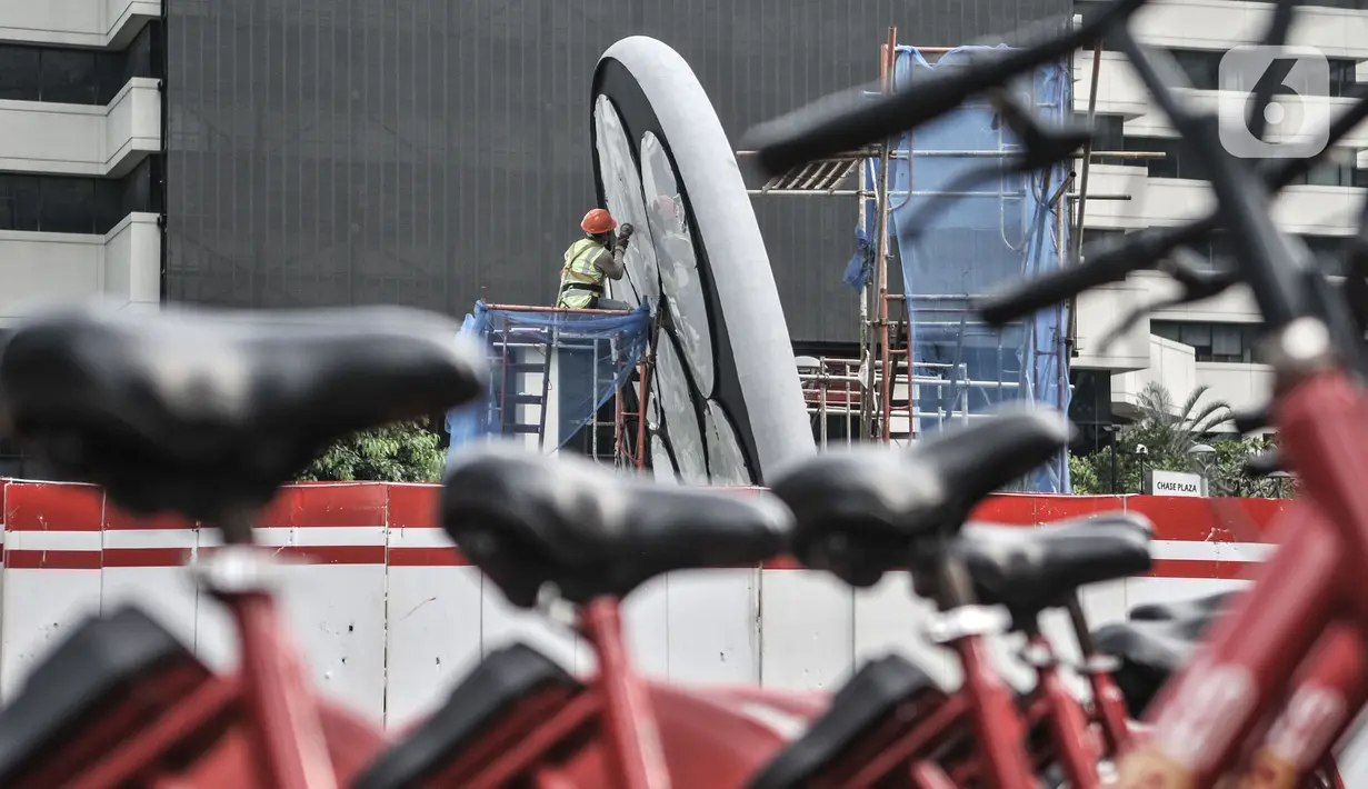 Pekerja saat menyelesaikan pembangunan Tugu Sepeda di Jalan Jenderal Sudirman, Jakarta, Senin (5/4/2021). Pembangunan tugu tersebut sebagai pengingat momentum penggunaan sepeda yang masif digunakan masyarakat Ibu Kota pada masa pandemi Covid-19. (merdeka.com/Iqbal S. Nugroho)