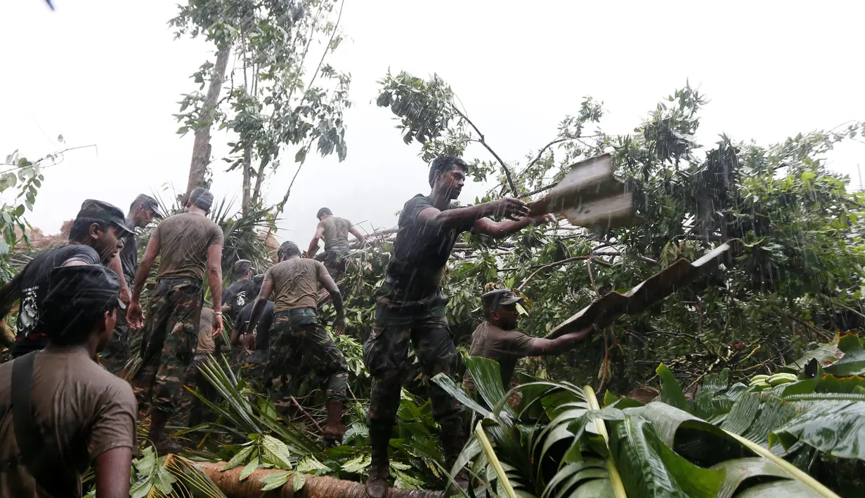 Petugas Militer Sri Lanka membantu membersihkan puing rumah warga usai longsor di Desa Elangipitiya, Aranayaka, Sri Lanka (19/5). Ratusan warga dikabarkan hilang akibat tanah longsor tersebut. (REUTERS/Dinuka Liyanawatte)