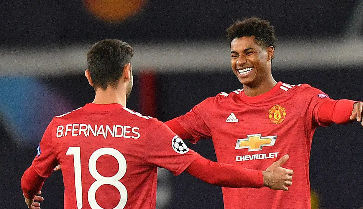 Striker Manchester United, Marcus Rahford merayakan gol bersama Bruno Fernandes dalam lanjutan Liga Champions 2020/2021 di grup H saat menghadapi RB Leipzig di Stadion Old Trafford, Kamis (29/10/2020) dini hari WIB. Manchester United menang 5-0 atas RB Leipzig. (AFP/Anthony Devlin).