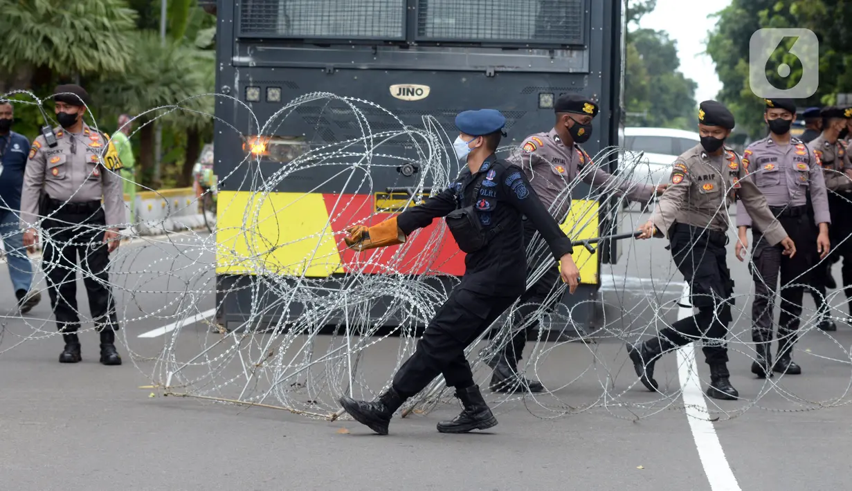 Polisi membentangkan pagar duri saat unjuk rasa buruh di kawasan Patung Kuda, Jakarta, Rabu (10/11/2021). Buruh menuntut pemerintah untuk mencabut UU Cipta Kerja dan meminta Presiden Joko Widodo atau Jokowi untuk mundur. (merdeka.com/Imam Buhori)