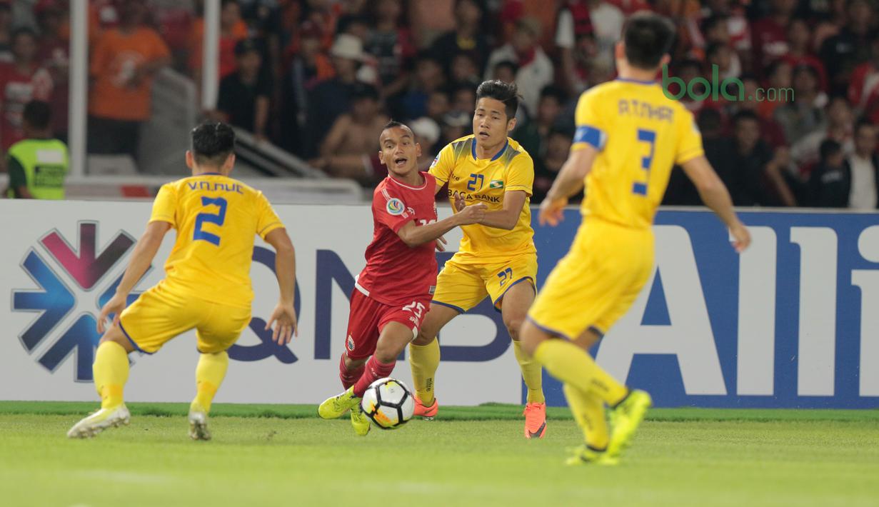 Pemain Persija Jakarta, Riko Simanjuntak berusaha melewati kepungan para pemain Song Lam Nghe An FC pada laga Piala AFC 2018 di Stadion Utama GBK, Senayan, Jakarta, (13/3/2018). Persija Jakarta menang 1-0. (Bola.com/Nick Hanoatubun)