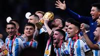 Pemain Argentina Lionel Messi bersama rekan setimnya mengangkat trofi juara usai mengalahkan Prancis pada pertandingan sepak bola final Piala Dunia 2022 di Stadion Lusail, Lusail, Qatar, 18 Desember 2022. Argentina menang 4-2 dalam adu penalti setelah pertandingan berakhir imbang 3 -3. (AP Photo/Natacha Pisarenko)
