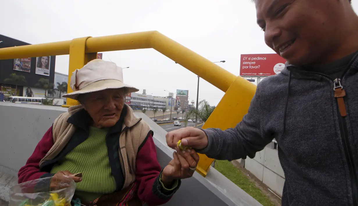 Alejandra Baldani, nenek 78 tahun, menjual permen kepada salah satu pejalan kaki di sebuah jembatan penyeberangan di distrik San Borja, Lima, 22 Oktober 2015. Baldani mendapatkan sekitar USD 3 per hari dari hasil berjualan permen. (REUTERS / Mariana Bazo)