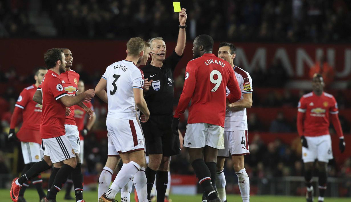 Pemain Manchester United, Romelu Lukaku menerima kartu kuning dari wasit Martin Atkinson saat melwan Burnley pada lanjutan Premier League di Old Trafford,  Manchester (26/12/2017).  MU bermain imbang 2-2. (AFP/Lindsey Parnaby)